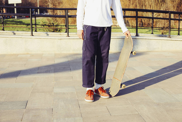 Boy standing with skateboard. Skateboarding Practice Freestyle Extreme Sports Concept - Fotoğraf, Görsel