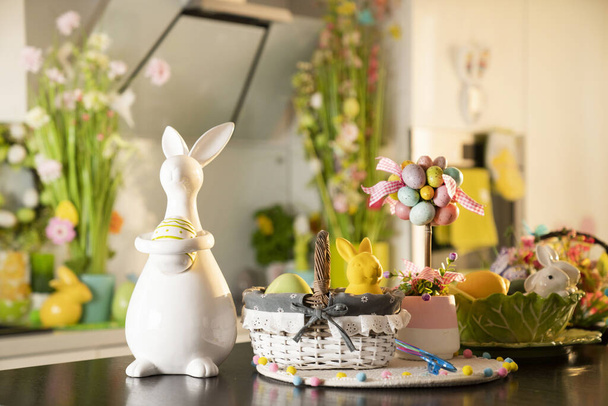 Easter theme. Easter decorations. Easter eggs in basket and easter bunnies. Bouquet of spring flowers. - Photo, Image