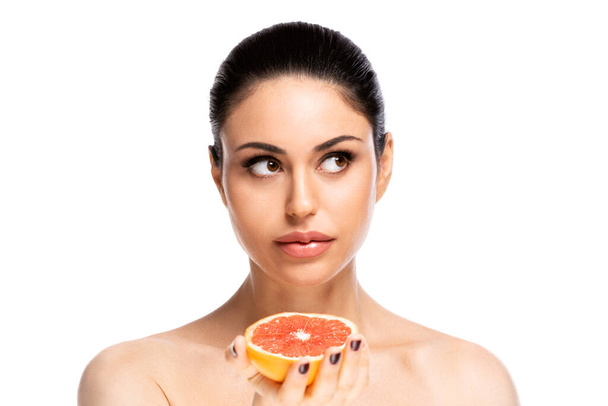Healthy food concept. Beautiful young woman holding piece of grapefruit, isolated over white background - Φωτογραφία, εικόνα