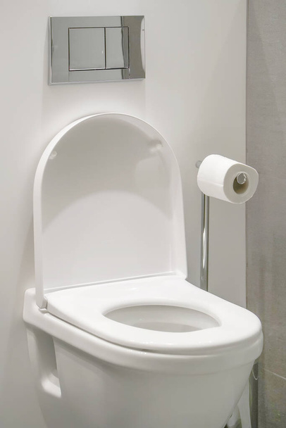 Vécépapír tekercs otthon a mosdóban. Szekrény WC-csésze és tekercs WC-papír tartó luxus szálloda. - Fotó, kép
