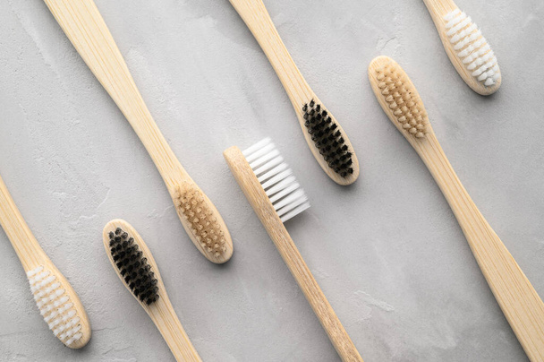 Zero conceito de desperdício. Conjunto de escovas de dentes de bambu ecológicas em um fundo de concreto cinza
. - Foto, Imagem