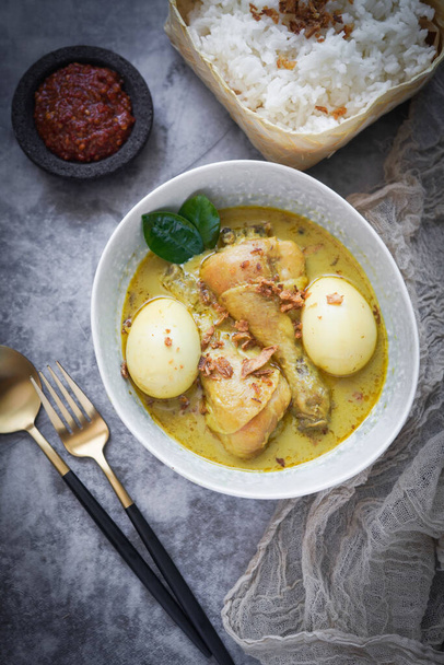 Alimentos indonesios: Opor Ayam (Curry blanco indonesio), Pollo cocido en leche de coco y especias y servido para celebrar Idul Fitri / Lebaran
 - Foto, imagen