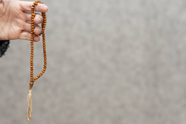 Hand holding a muslim rosary beads or Tasbih  - Fotó, kép
