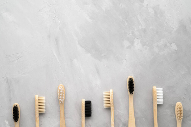 Geen afval concept. Set van milieuvriendelijke bamboe tandenborstels op een grijze betonnen achtergrond. - Foto, afbeelding