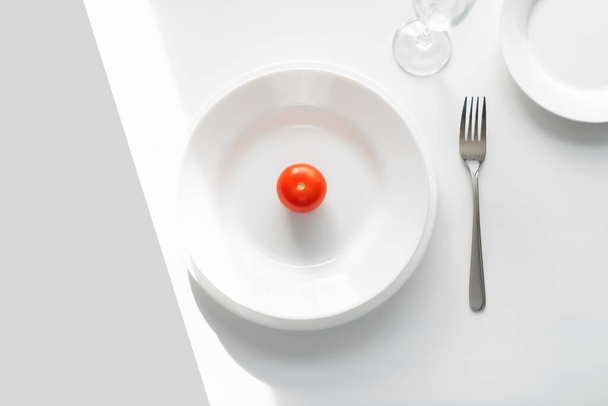 Table setting example. white plates on a white background in the light of the sun. Tomato on a plate. place for text - Fotografie, Obrázek