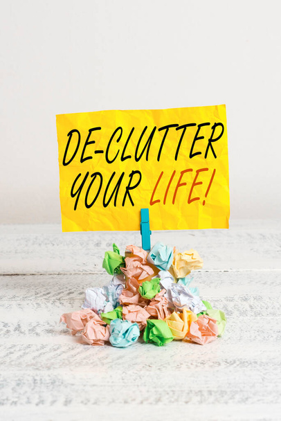 Word writing text De Clutter Your Life. Business concept for remove unnecessary items from untidy or overcrowded places Reminder pile colored crumpled paper clothespin reminder white wooden space. - Photo, Image