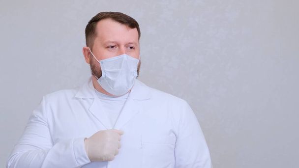 Doctor male coughs in a protective mask infected with a virus or coronavirus. - Foto, immagini