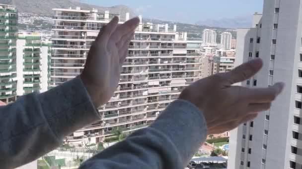 Kobieta bije brawo personelowi medycznemu z balkonu. Ludzie w Hiszpanii klaskający na balkonach i oknach wspierających pracowników służby zdrowia podczas pandemii koronawirusowej - Materiał filmowy, wideo