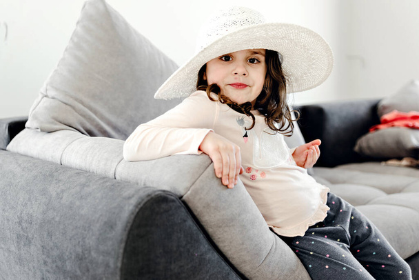 young girl in a hat posing in front of the camera,child holds nuts in his hand and smiles,girl advertises nuts,beautiful girl resting on the weekend,home photo shoot - Φωτογραφία, εικόνα