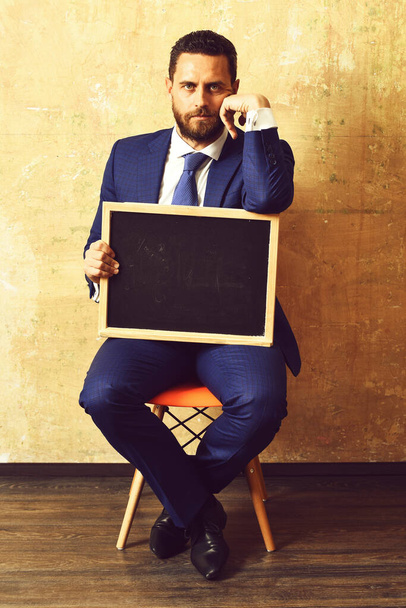 blackboard in hands of teacher man or businessman in suit - Фото, зображення
