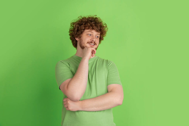 Caucasian young mans monochrome portrait on green studio background - Foto, Imagem