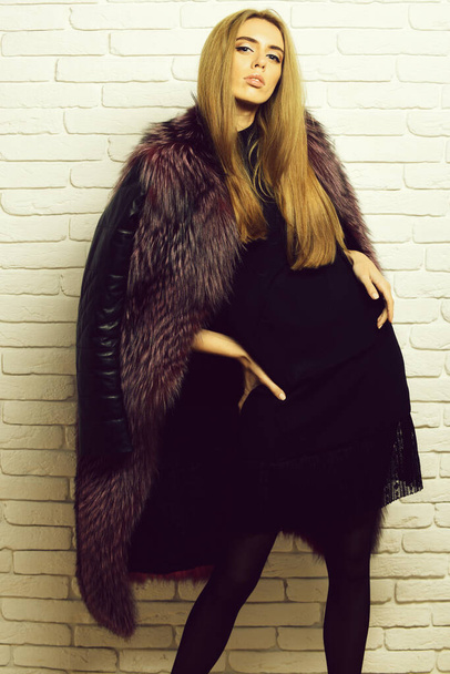 fashionable sexy woman in fur on white brick wall studio background - Фото, изображение
