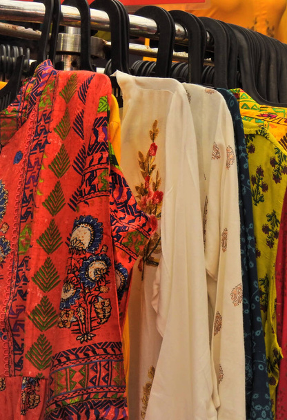 Vista de cerca de la mujer india ropa de la parte superior de la moda o kurtas tradicionales colgados en perchas en exhibición en una tienda al por menor
 - Foto, Imagen
