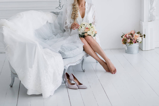 bride in peignoir with a bouquet of flowers - Foto, imagen