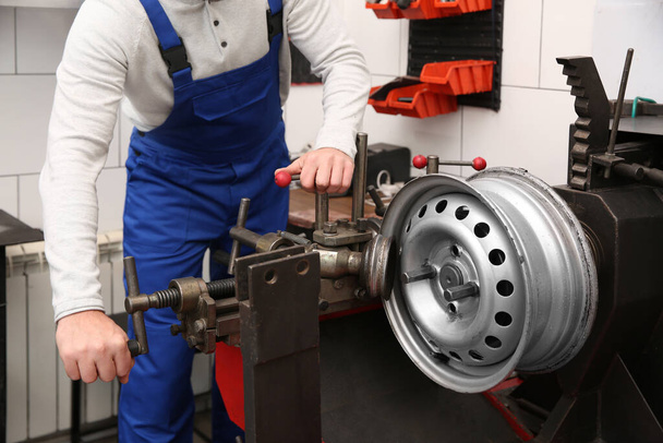 Mechanic working with car disk lathe machine at tire service, closeup - Foto, Imagem