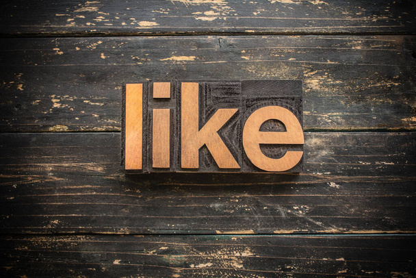 The word "LIKE" written in vintage wood letterpress type on a vintage rustic background. - Foto, afbeelding
