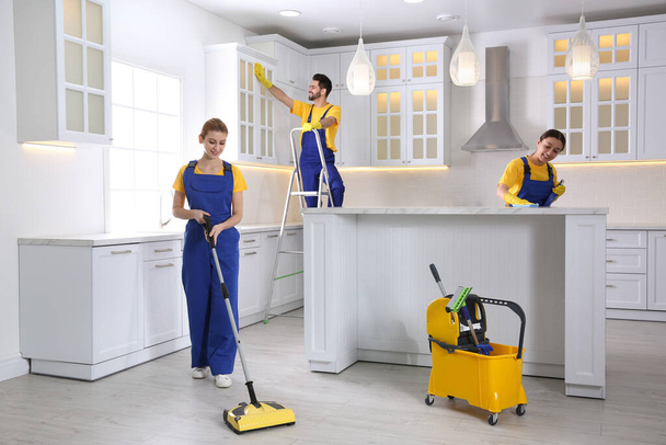 Команда професійних прибиральників прибирання сучасної кухні
 - Фото, зображення