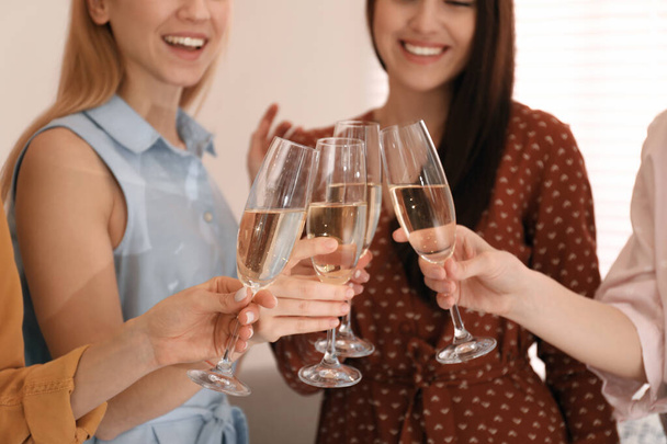 Mladé dámy cinkají sklenicemi šampaňského, detailní záběr. Dámský den - Fotografie, Obrázek