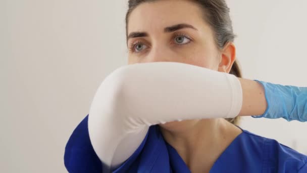 doctor or nurse coughing covering mouth with elbow - Filmati, video