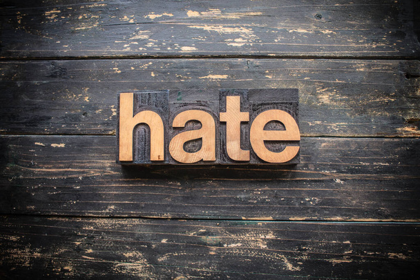 ヴィンテージの木の活版印刷で書かれた「 HATE 」という言葉は、素朴な背景にあります。. - 写真・画像