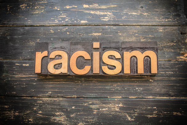 La palabra "RACISMO" escrita en tipografía de madera vintage sobre un fondo rústico vintage
. - Foto, Imagen