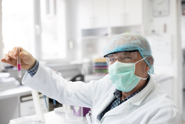 Médico sosteniendo tubo de ensayo con sustancias químicas en laboratorio. Salud y concepto médico
 - Foto, Imagen