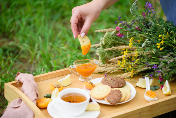 Tasty shortbread, apricot jam, ginger, fragrant tea, lemon, in the summer cottage style with wildflowers - Fotoğraf, Görsel