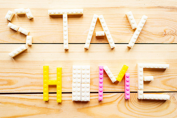 Frase Stay at Home da costruttore di giocattoli su sfondo in legno. Concetto di quarantena
 - Foto, immagini