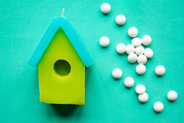 Spielzeughaus und Pillen auf grünem Hintergrund. Quarantäne-Konzept - Foto, Bild