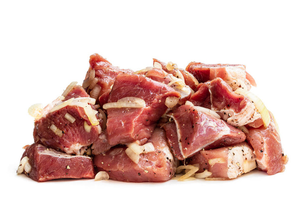 Gemarineerde varkensvlees plakjes met ui en specerijen geïsoleerd op wit  - Foto, afbeelding