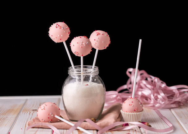 Pink cake pops in a jar of sugar in the form of a bouquet on a wooden background. Tasty desserts - Photo, Image