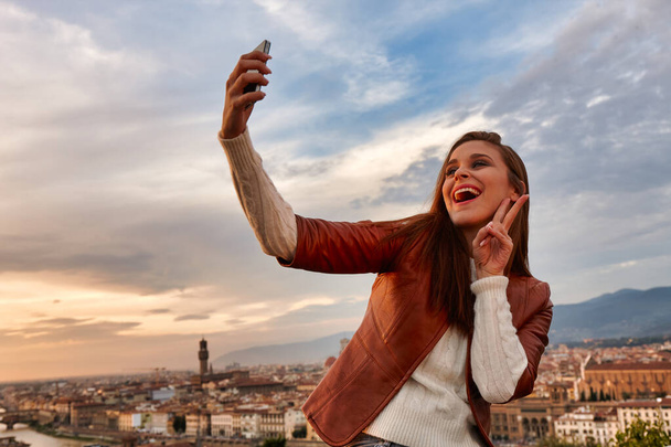 Mladá žena, jak se fotí s panoramatem Florencie za zády. - Fotografie, Obrázek
