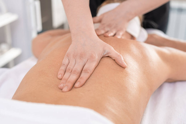 Close-up de massagista irreconhecível fazendo massagem terapêutica para as costas para relaxar a mulher no salão SPA
 - Foto, Imagem