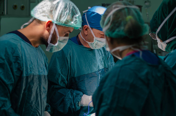 Médico concentrado, assistente e enfermeiro em um paciente durante uma operação de histerectomia em um hospital. Ele está a usar electrocautério em operação.
. - Foto, Imagem