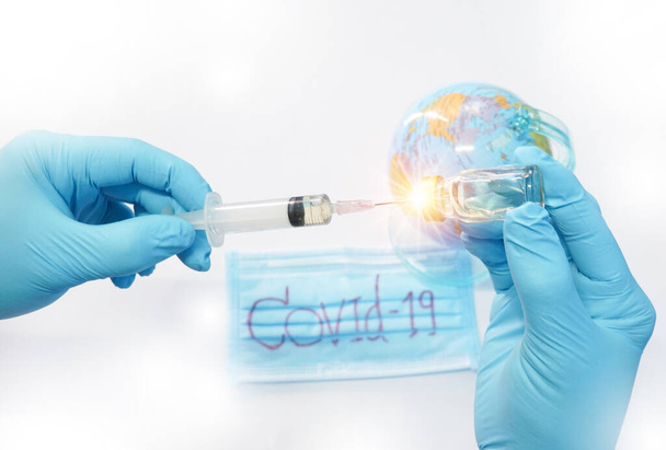 Closeup Scientists transparent medical gloves using syring Prepare a trial drug for the vaccine against Covid-19 on the world. Scientific and medical concept - Foto, Bild