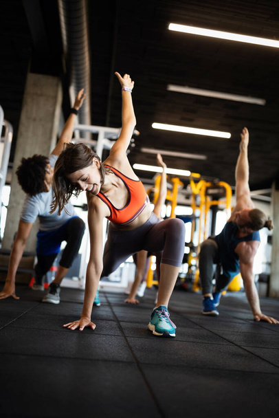 Beautiful fit friends working out in gym togetherFitness, sport, training and lifestyle concept. Group of fit people exercising in gym - Foto, Imagen