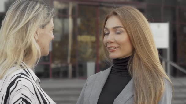 Две женщины-коллеги с радостью разговаривают на открытом воздухе - Кадры, видео