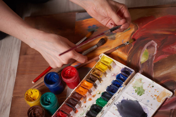 A mester a munkában gouache festékkel rajzolt, csendélet. A mester festékes dobozai és keféi. - Fotó, kép