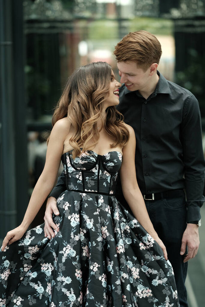 beautiful couple-a girl in a magnificent dress and a guy in a black shirt and trousers are in a building with a beautiful interior - Foto, afbeelding