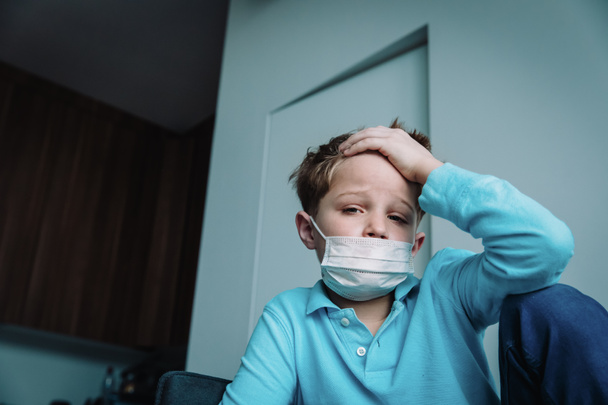 Beteg gyermek fertőzéssel vagy vírussal, fiú maszkot visel otthon - Fotó, kép