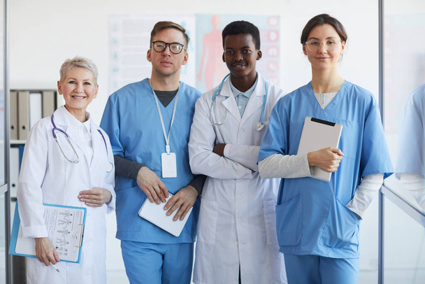Multi-ethnic group of doctors looking at camera while posing together in clinic interior - Photo, Image
