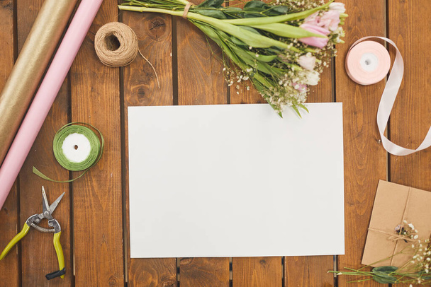 Top view background of blank sign on wooden table with pink Spring flowers and bouquet decorating supplies, copy space - Φωτογραφία, εικόνα