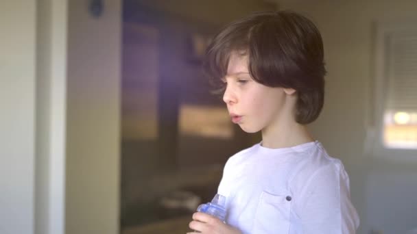 回転計を使用して若い男の子,肺容量と力の消耗量を測定します。自宅でスピロメータを使用して少年のクローズアップ. - 映像、動画
