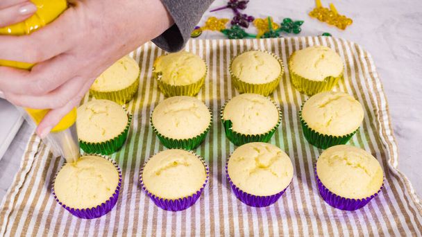 Βήμα-βήμα. Cupcakes βανίλιας με ιταλική βουτυρόκρεμα για τον εορτασμό του Mardi Gras. - Φωτογραφία, εικόνα