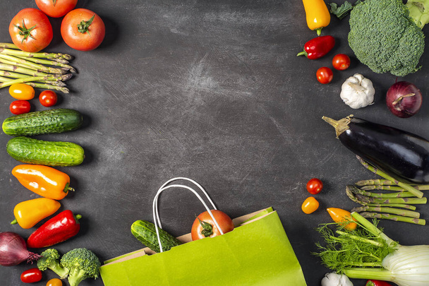 Exposición de verduras orgánicas frescas en mesa negra. tomate, pimienta, brócoli, cebolla, ajo, pepino, berenjena, guisantes de ojos negros, bolsa ecológica
. - Foto, imagen