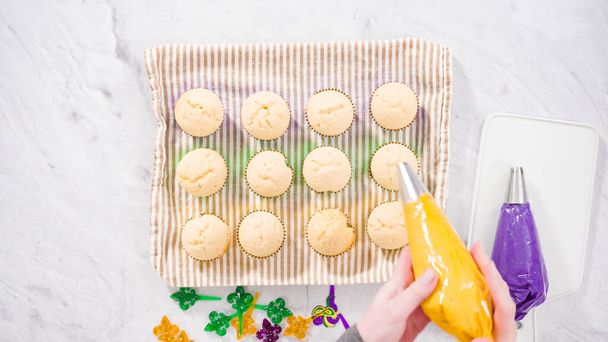 Flat lay. Step by step. Frosting vanilla cupcakes with Italian buttercream icing for Mardi Gras celebration. - Photo, Image
