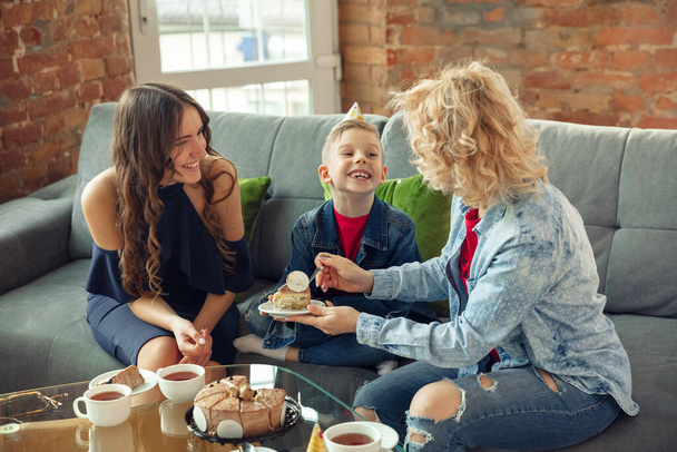 Mother, son and sister at home having fun, comfort and cozy concept, celebrating birthday - Фото, зображення