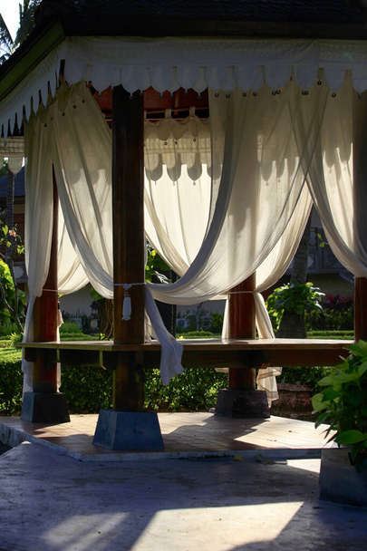 Rahatlamak ya da meditasyon yapmak için beyaz perdeli bir çardak. Bali Adası, Endonezya. - Fotoğraf, Görsel