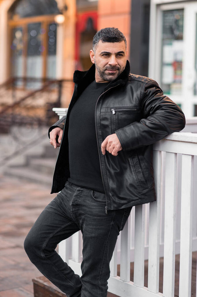a man in a leather jacket on the background of the metropolis. eastern appearance of the model. Arab - Фото, изображение