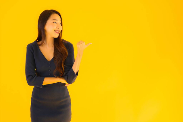 Portrait beautiful young asian woman with action on isolated yellow background - Φωτογραφία, εικόνα